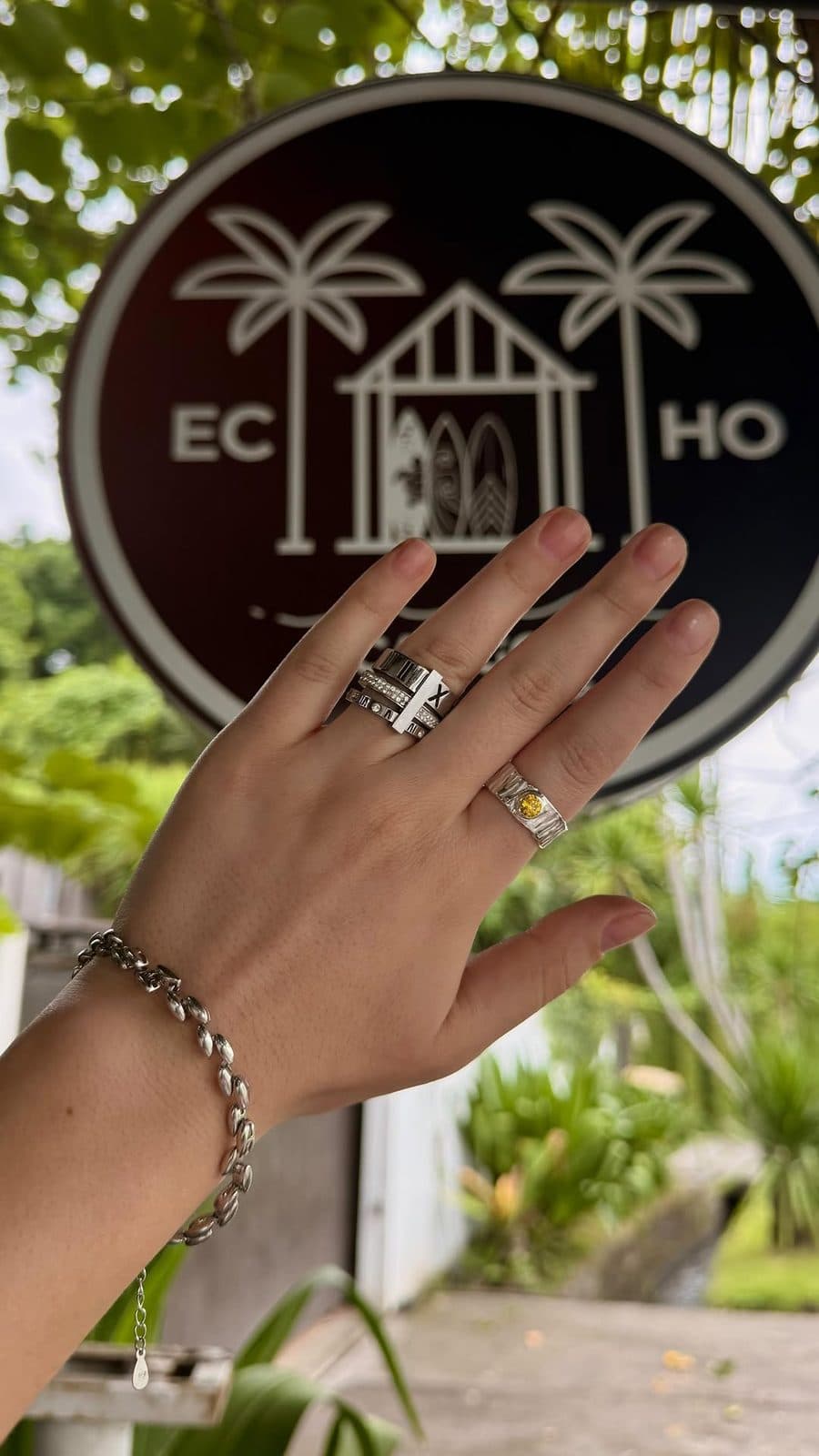 Student wearing handmade silver rings in front of the Echo Silver Canggu sign