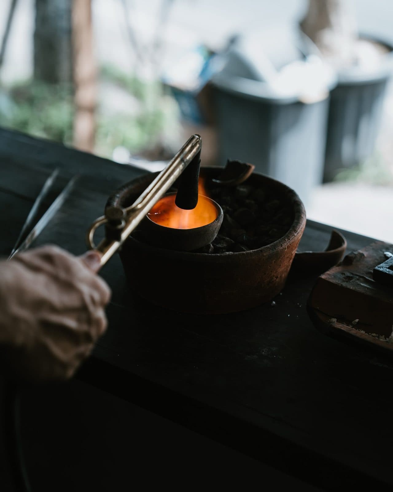 Silver being melted with a torch in a clay crucible